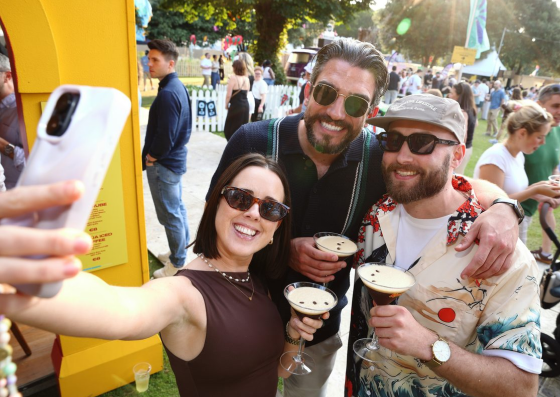 Attendees taking a group photo with a smartphone at an event